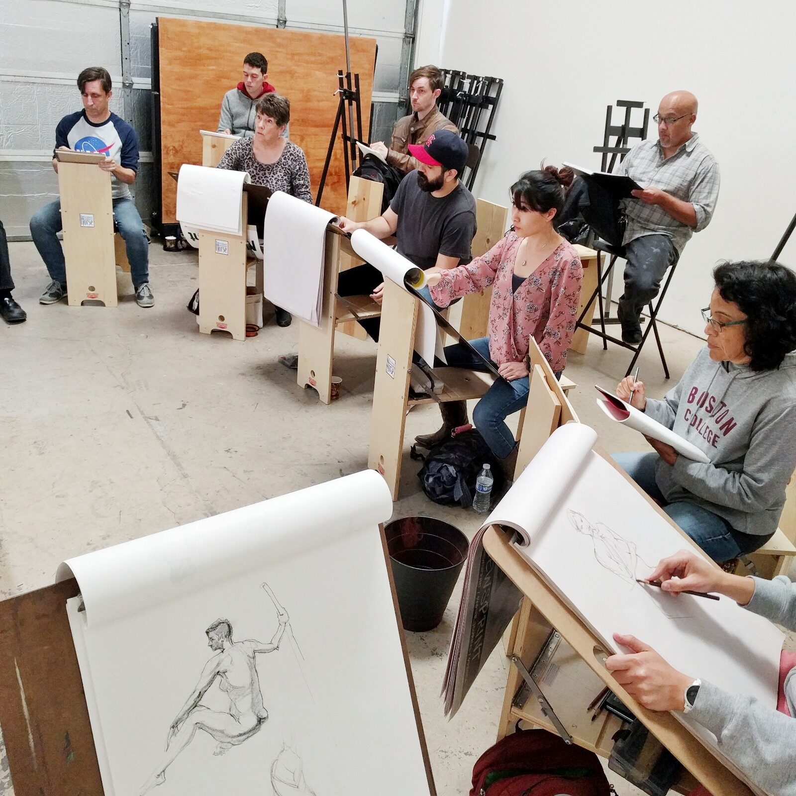 Group of artists on benches drawing